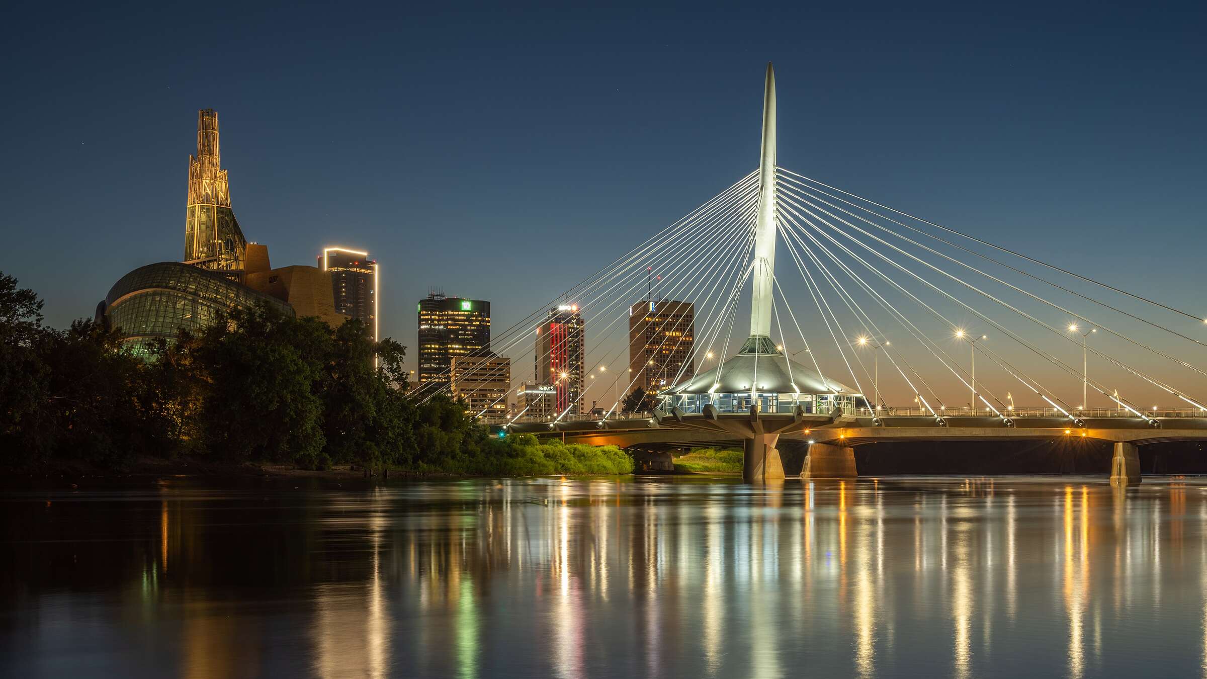Cable-stayed footbridge over a river at dusk